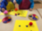 preschoolers dropping painted pompoms onto paper