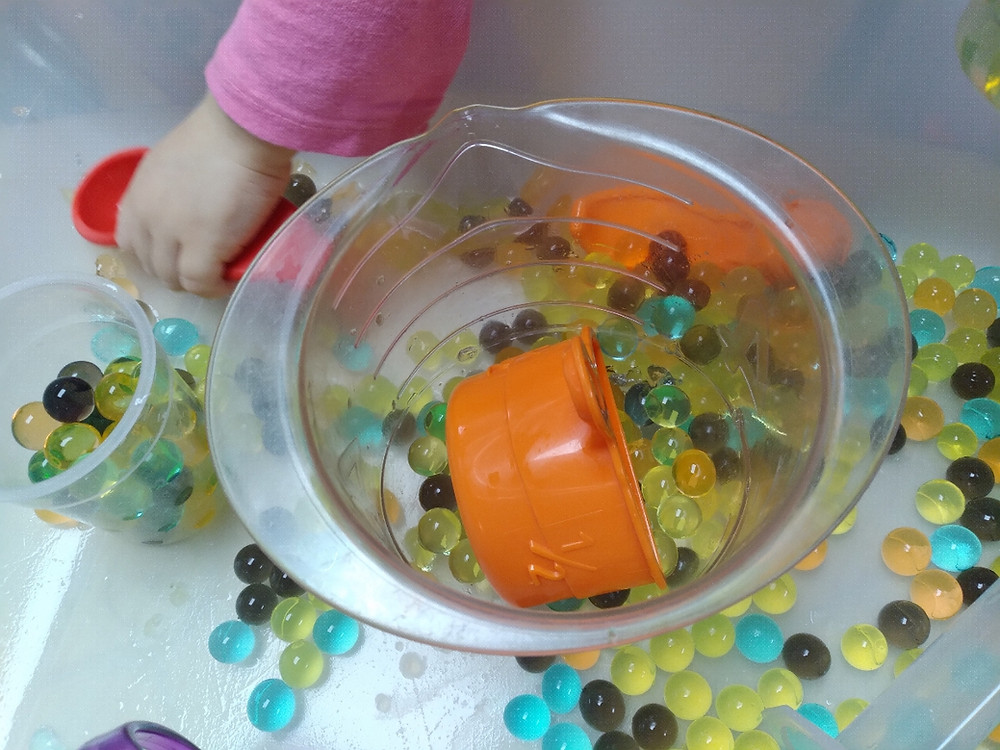 fall water bead sensory bin with measuring cups and spoons