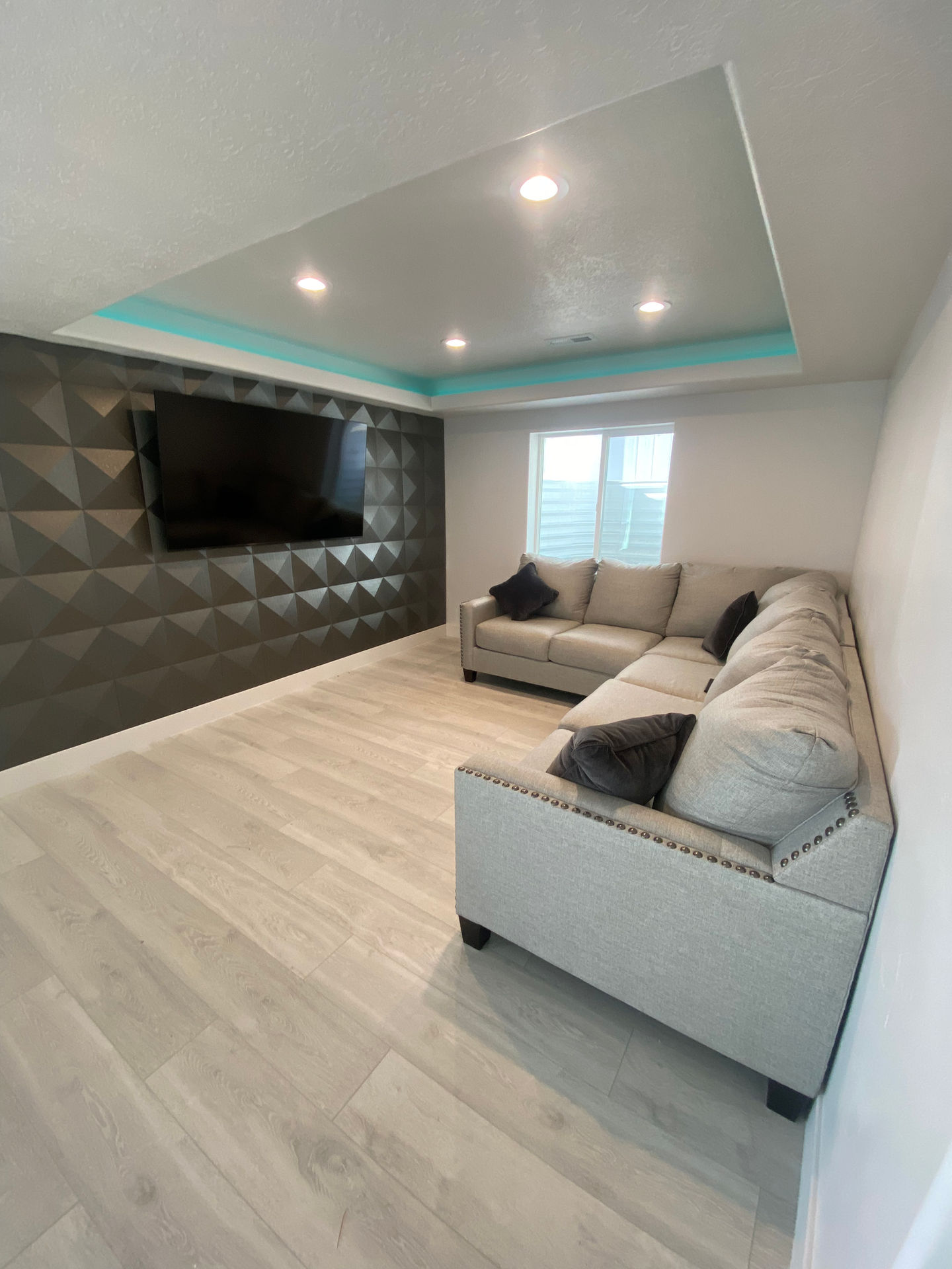 Modern living room with sectional sofa and wall-mounted TV.