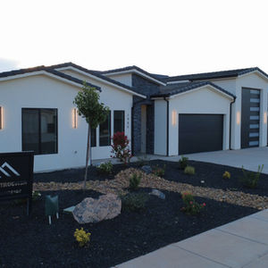 Modern house with minimalist landscaping and dark accents.