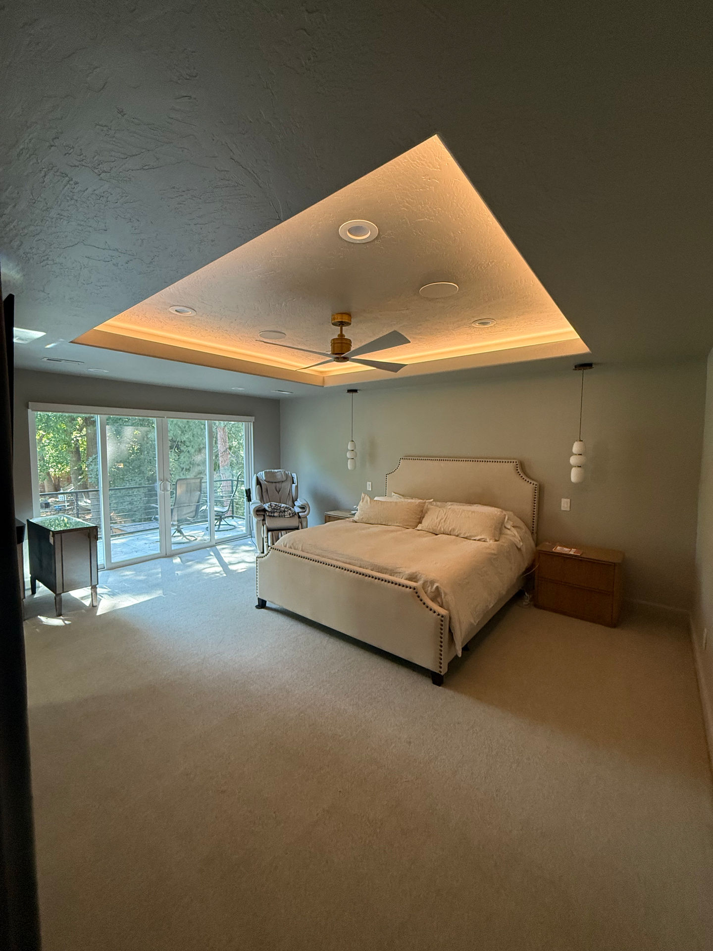 Modern bedroom with large windows and ceiling lights.