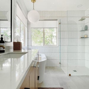 Modern white bathroom with glass shower and bathtub.