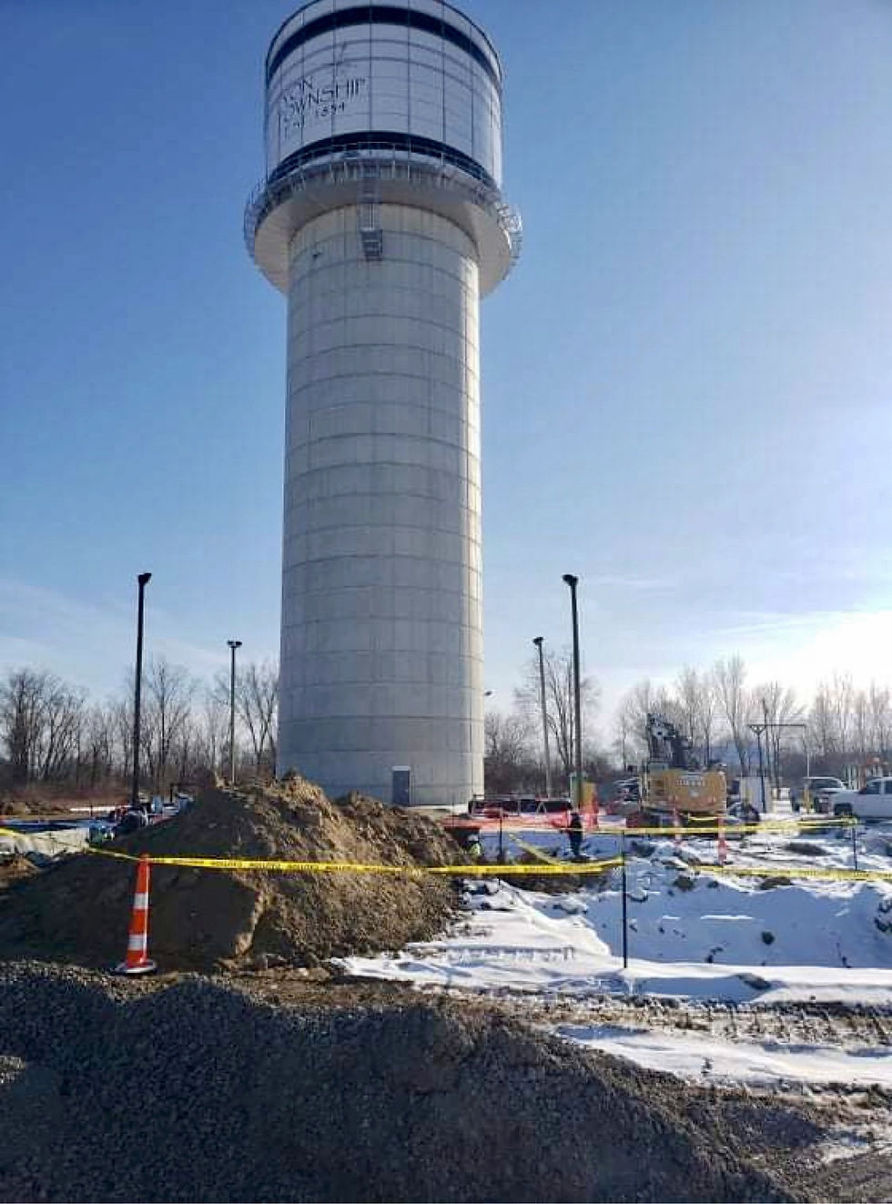 Eye-level view of a large elevated water storage tower against a clear sky