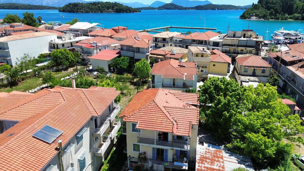 Vue aérienne des bâtiments et des toits de tuiles près de la plage de Nidri