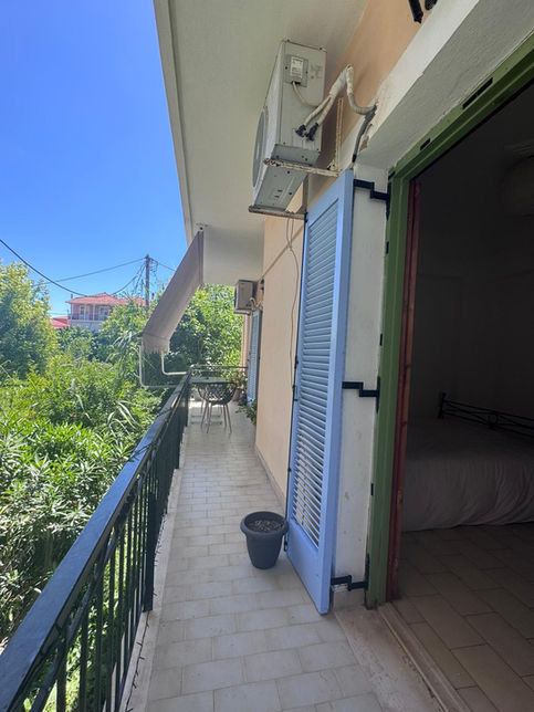 Ένα μακρύ μπαλκόνι σε ένα κτίριο πλήρως ανακαινισμένο στο Νυδρί με μπλε παντζούρια και κλιματισμό