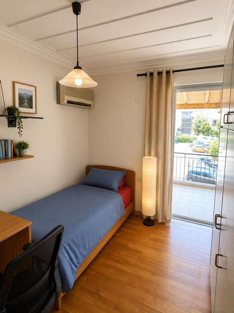 Bedroom with a blue single bed and a balcony in a building project in Nidri