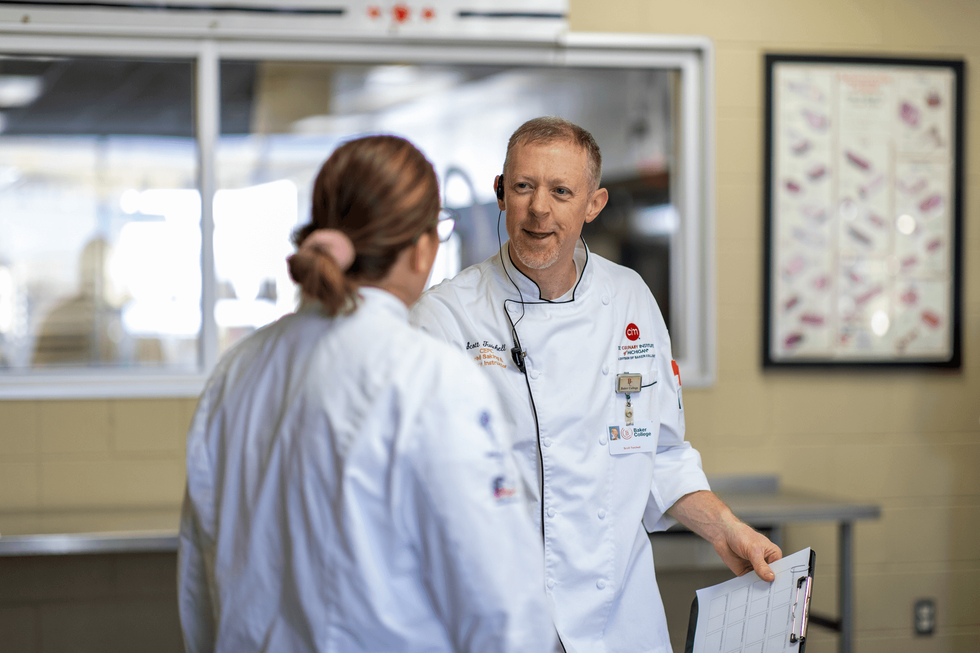 Two culinary instructors chatting.