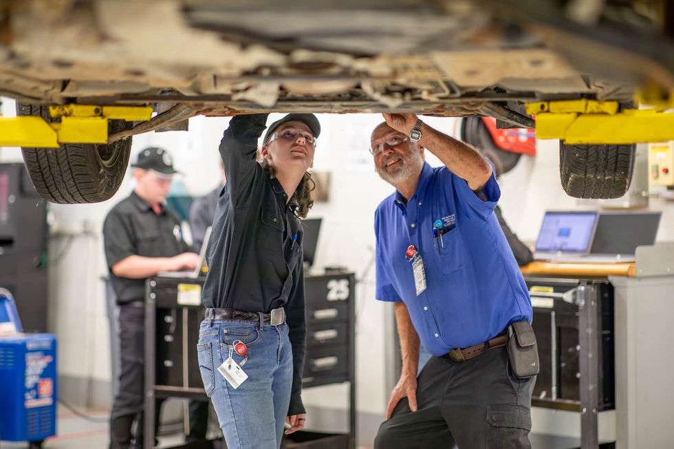 Student and teacher under a vehicle
