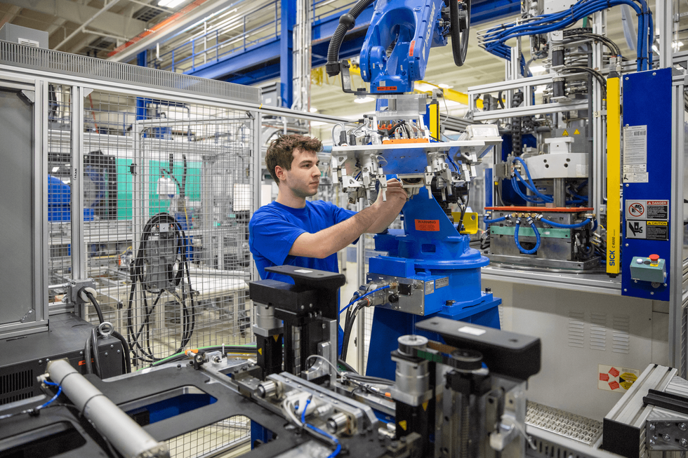 Mechatronics student working with factory equipment