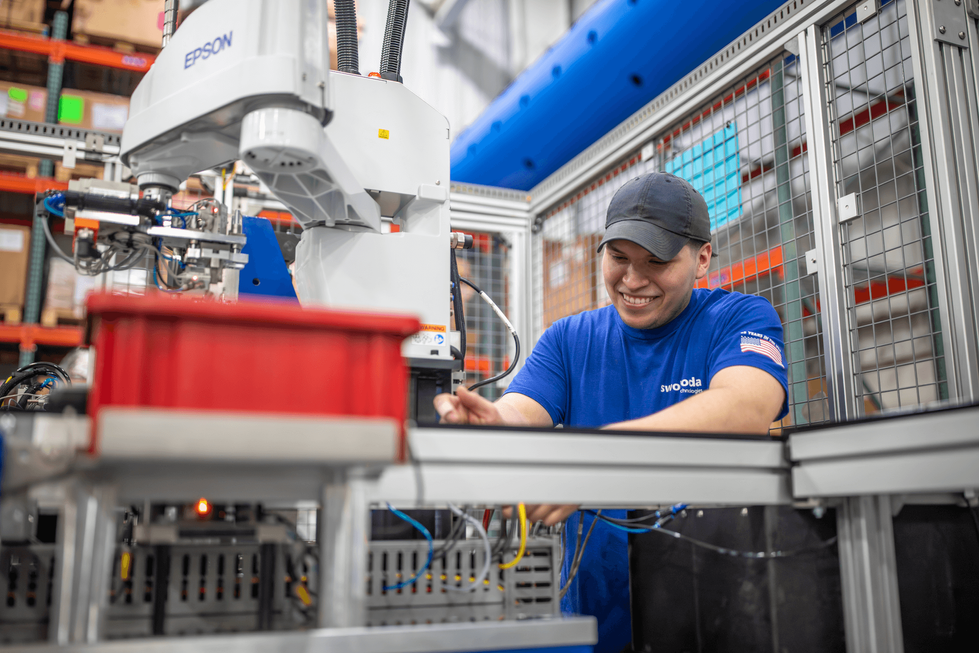 Man operates factory equipment.