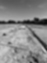 A gray and white photo of a dug trench.