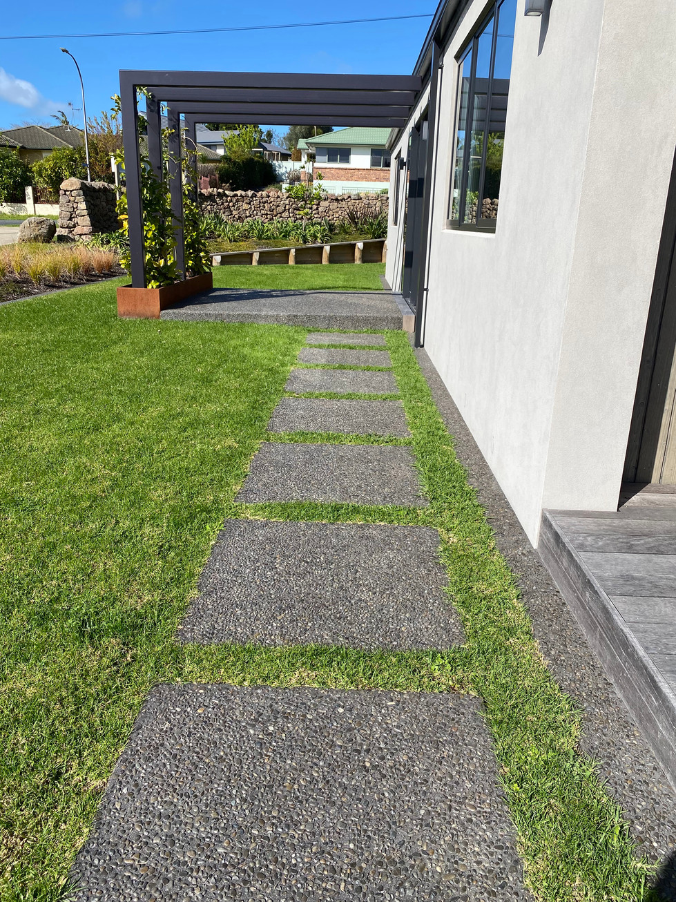 Exposed Awatoto Pebble, with 10kg black oxide. Concrete sealed. Pavers and mowing strips.