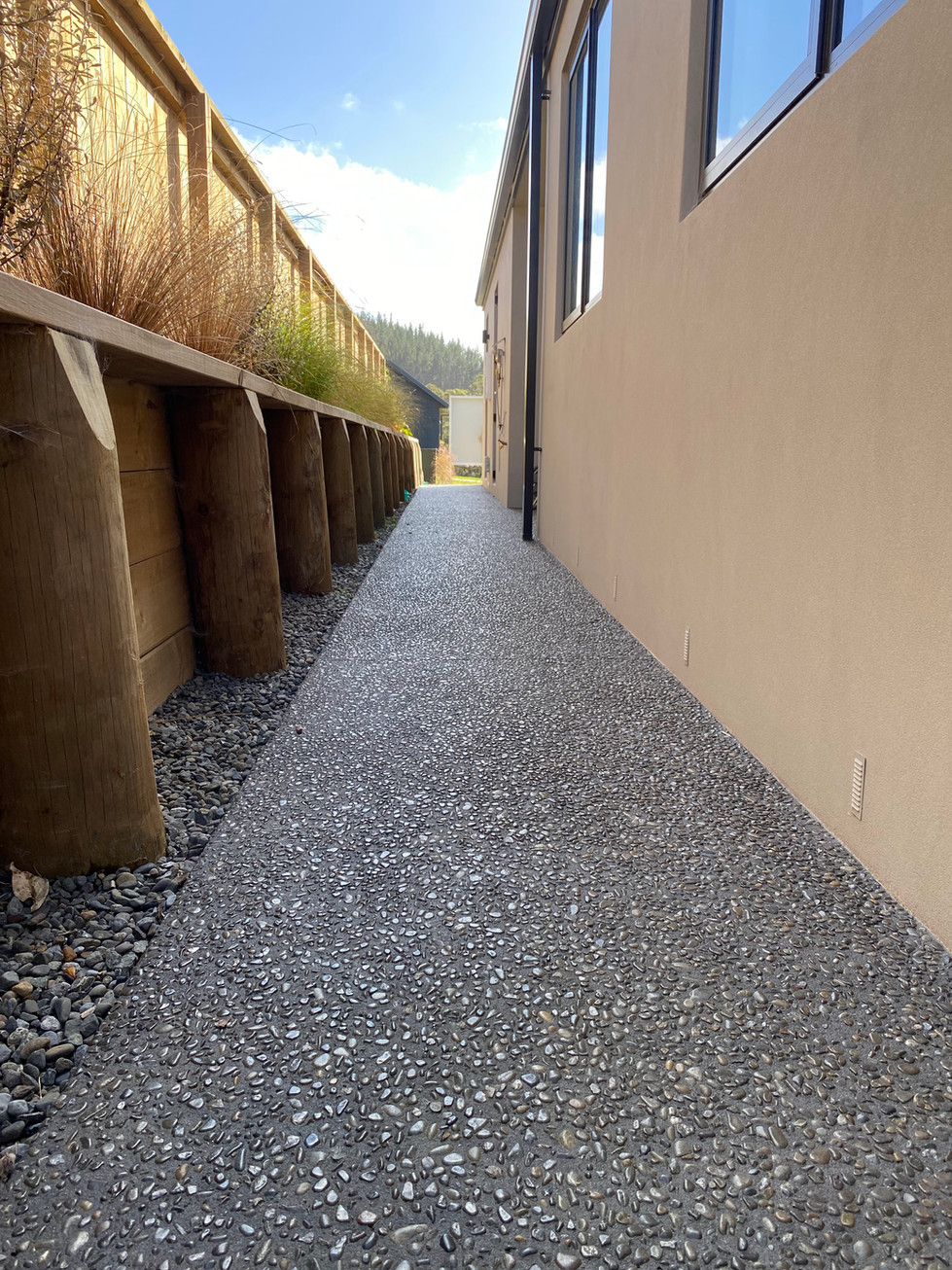 Exposed Awatoto Pebble, with 10kg black oxide. Concrete sealed. Footpath.