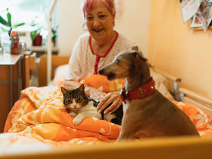 Señora disfrutando de la confianza de su perro y gato