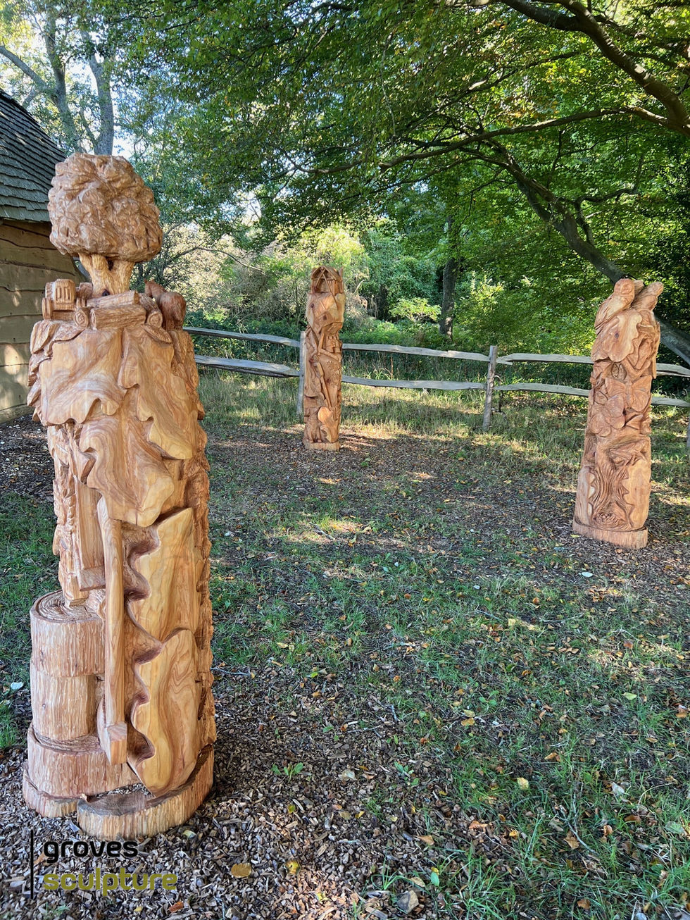 Photograph of three totem poles insitu.