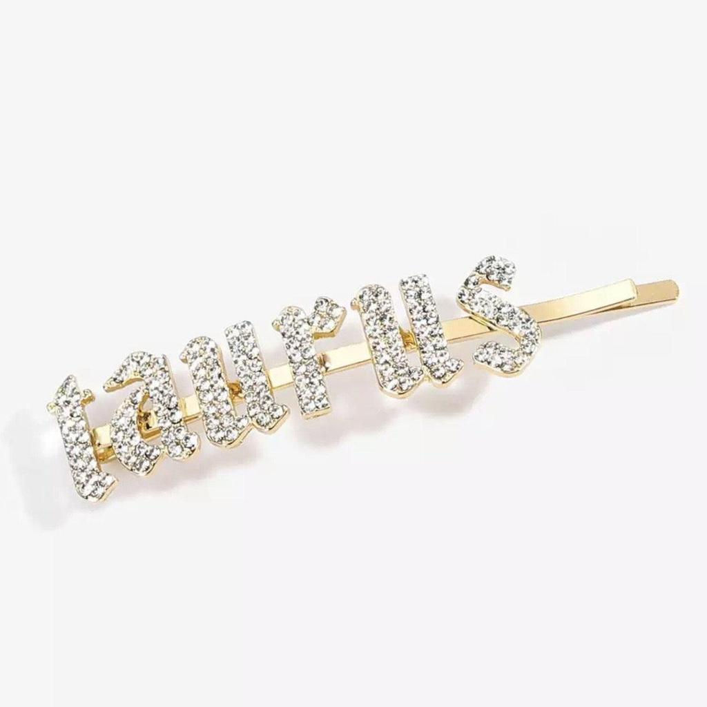 Gold Taurus rhinestone bobby pin hair clip sparkling on white background