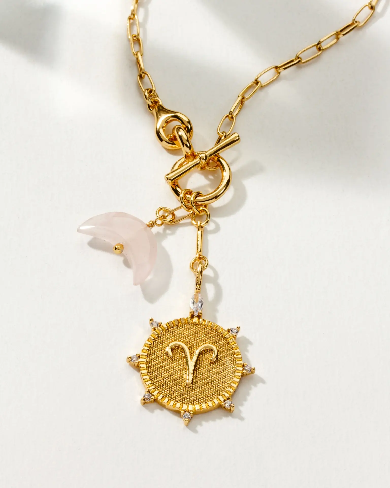 Close-up of Aries Lunar Necklace featuring a 14k gold-plated chain, front toggle clasp, and genuine rose quartz charm