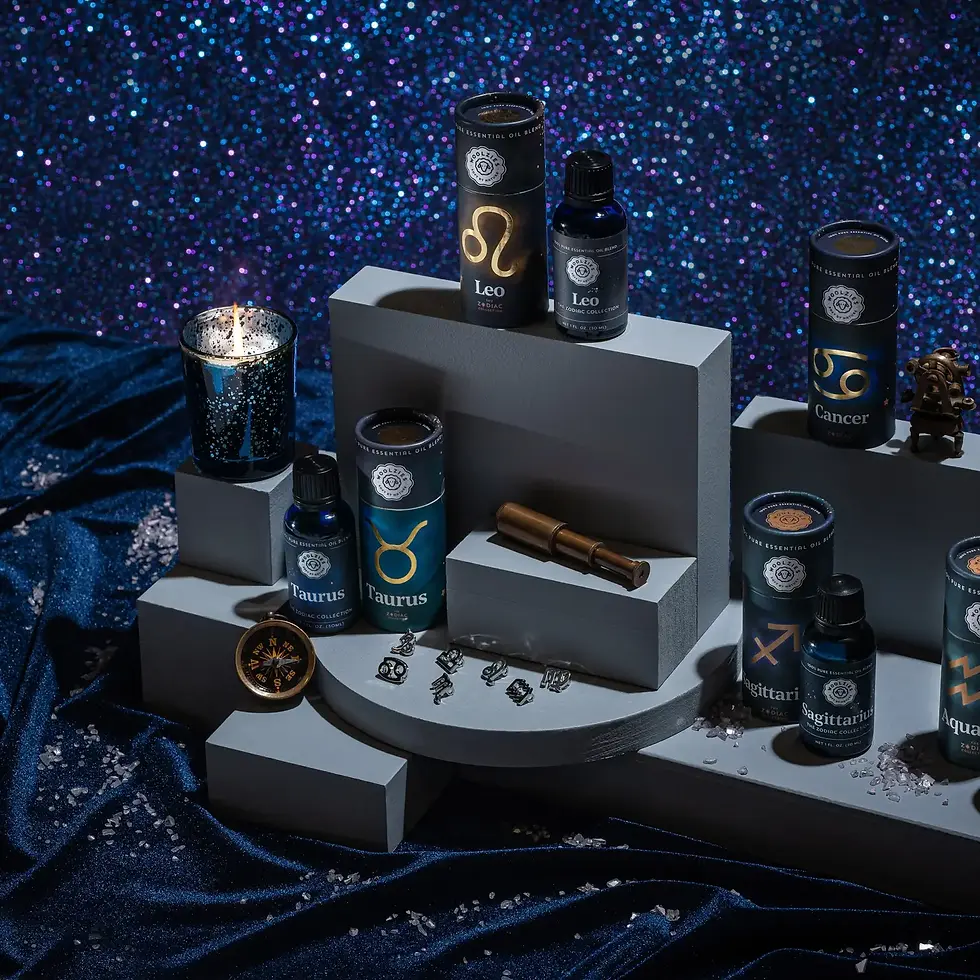 Aesthetic arrangement of Zodiac Essential Oils with candles and zodiac charms against a celestial-themed back drop