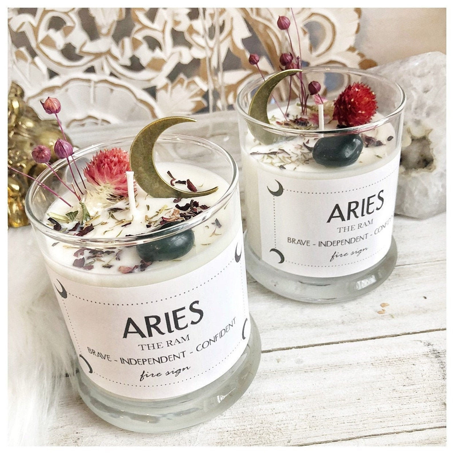 Two Aries zodiac candles styled on white painted wood with white crystals and soft, minimal decor
