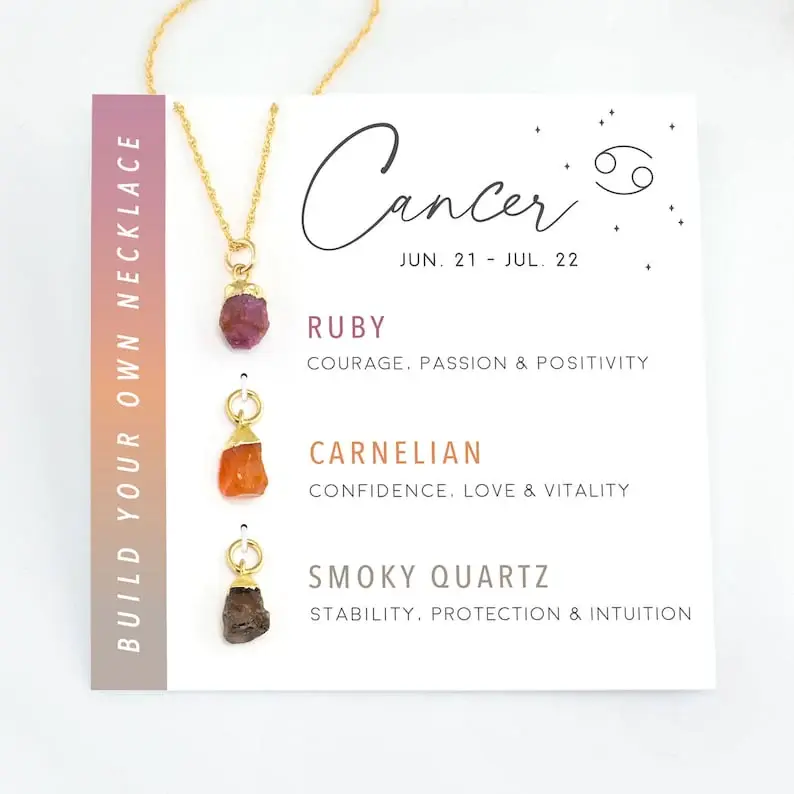 Cancer raw crystal necklace with Ruby, Carnelian, and Smoky Quartz displayed on white zodiac card against white background