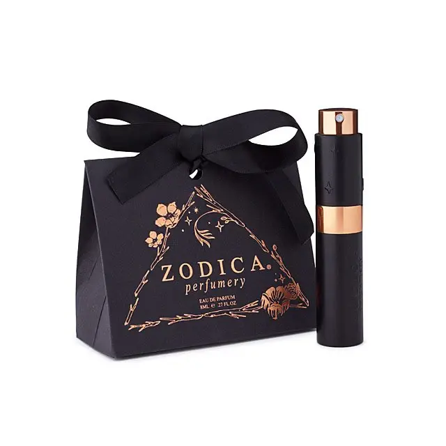 Zodiac twist & spritz perfume displayed next to its black gift box with zodiac ribbon charm - a luxe scent ritual