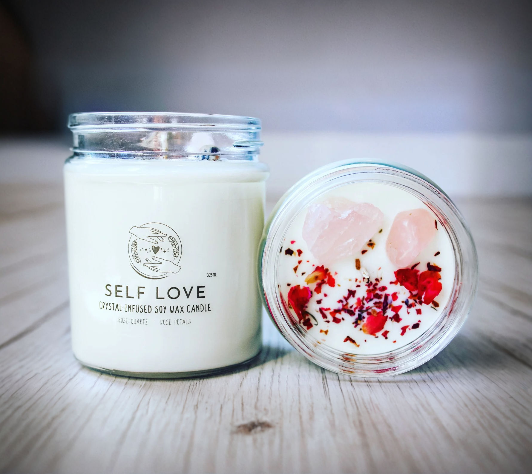 Self Love crystal intention candle with rose quartz and dried rose petals, shown next to a top-down view revealing crystals