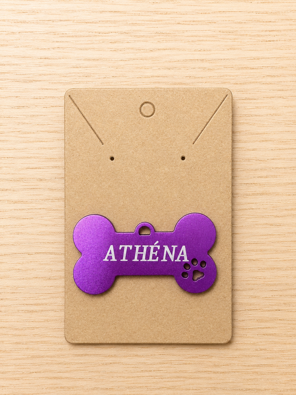 Médaille pour chien personnalisée en forme d’os violet, gravée avec le prénom Athéna et un motif patte.