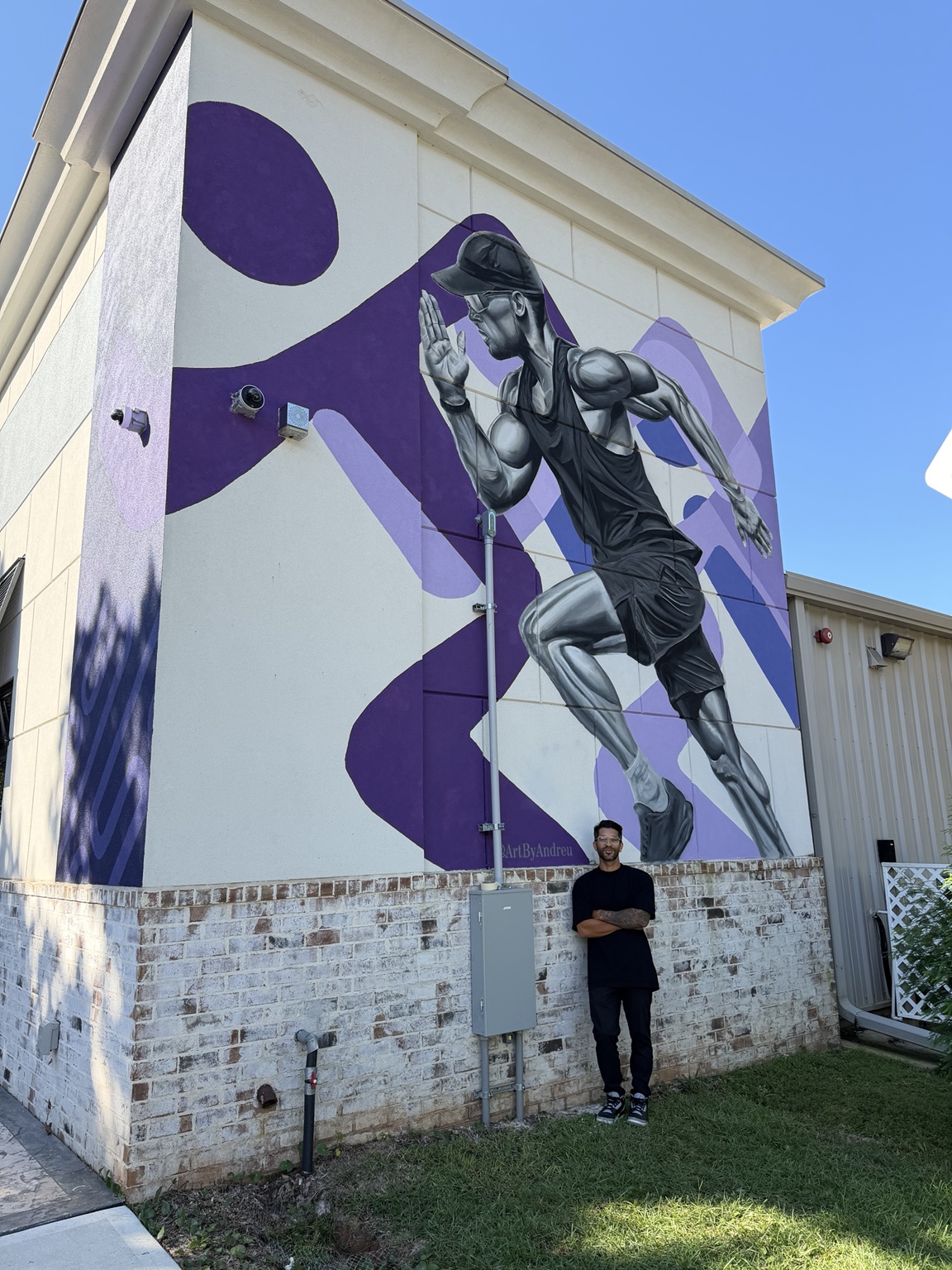 Anytime Fitness exterior mural with a grayscale runner and purple branded shapes in Pace Florida