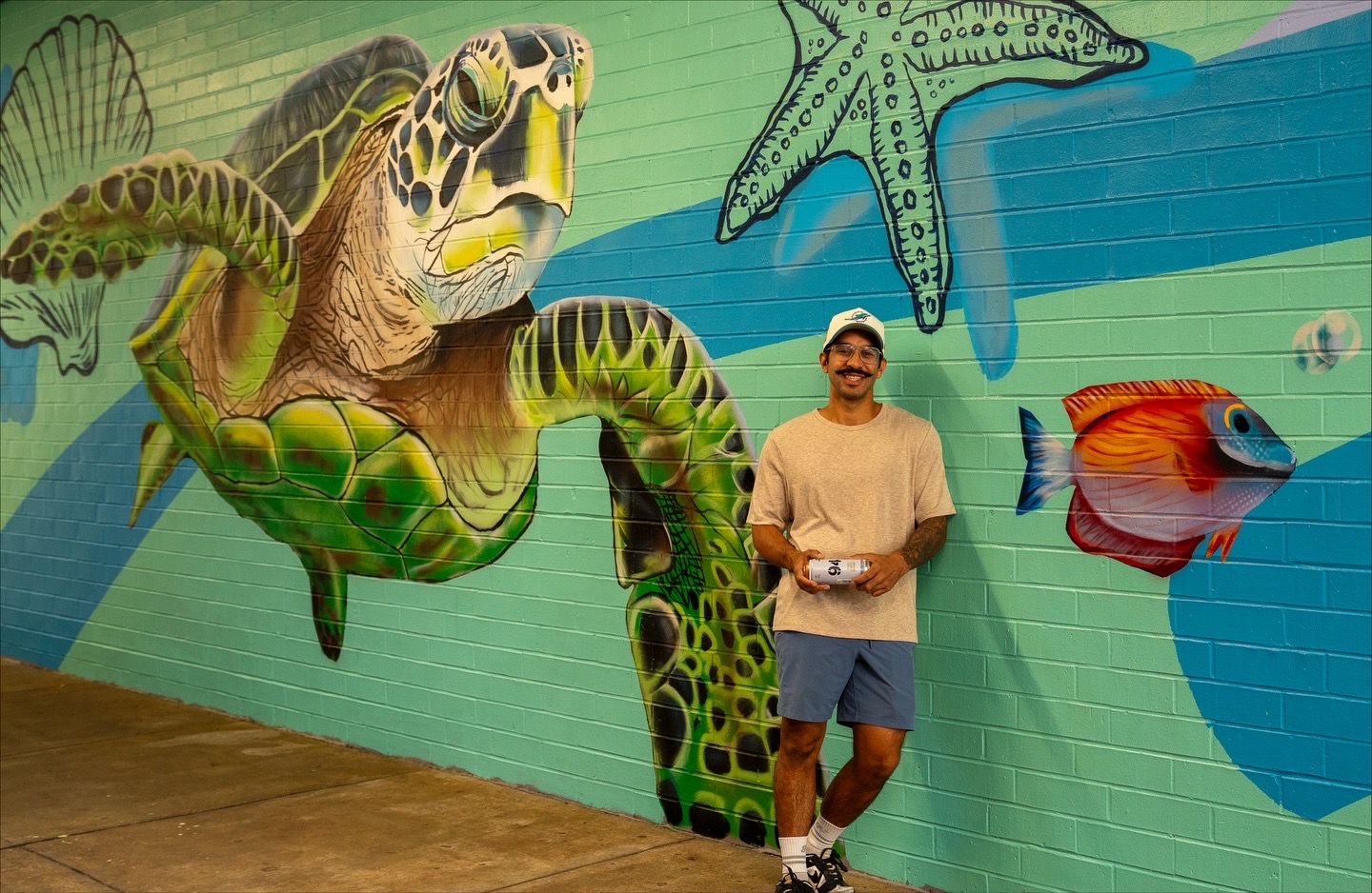 Florida Gulf Coast sea turtle mural with colorful fish and marine life, photographed with the mural artist
