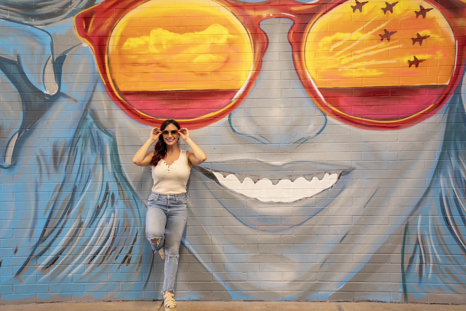 Visitor interacting with the Pensacola aviation-themed sunglasses mural in the Cordova Mall walkway