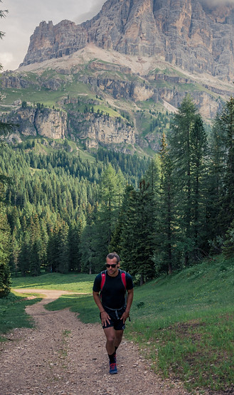 A male hiker walking a mountain trail, representing the personal journey of overcoming burnout and reaching new peaks.