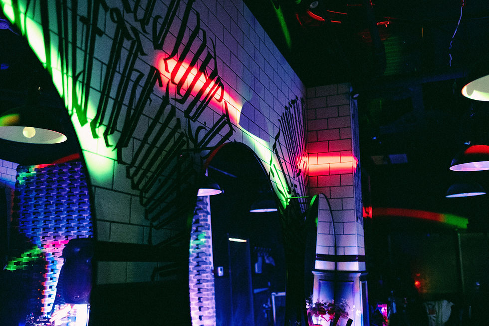 36th Chamber with neon red and green lights reflecting on tiled walls. Industrial lamps hang from the ceiling, creating a moody ambiance.