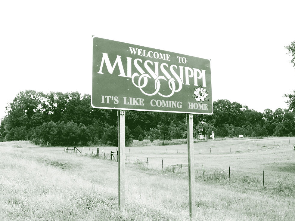 A highway road sign welcomes drivers to Mississippi with the slogan "It's like coming home"