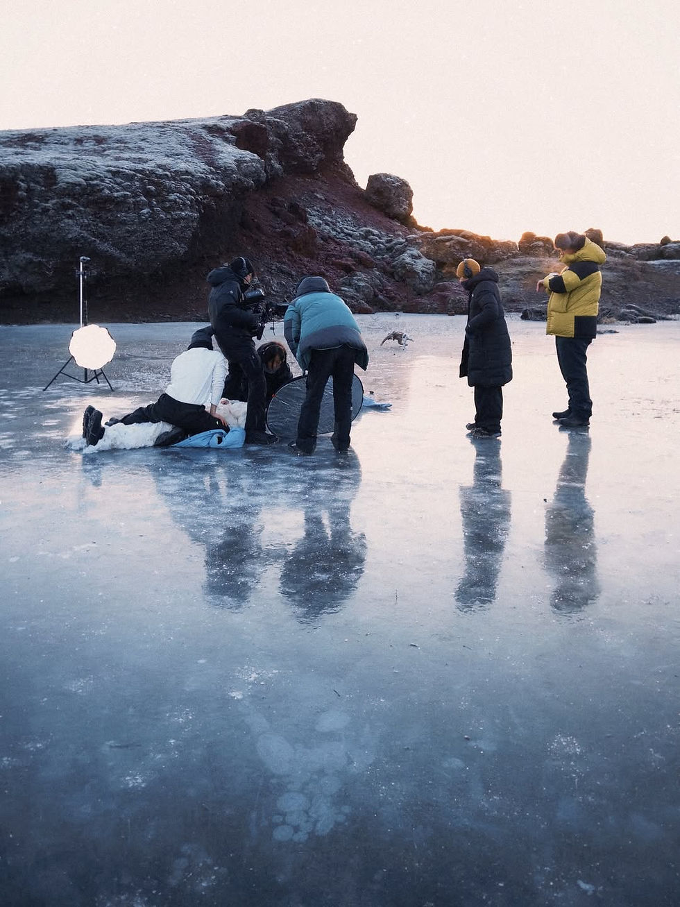 Eye-level view of a lone figure standing on a frozen Icelandic landscape under a cloudy sky