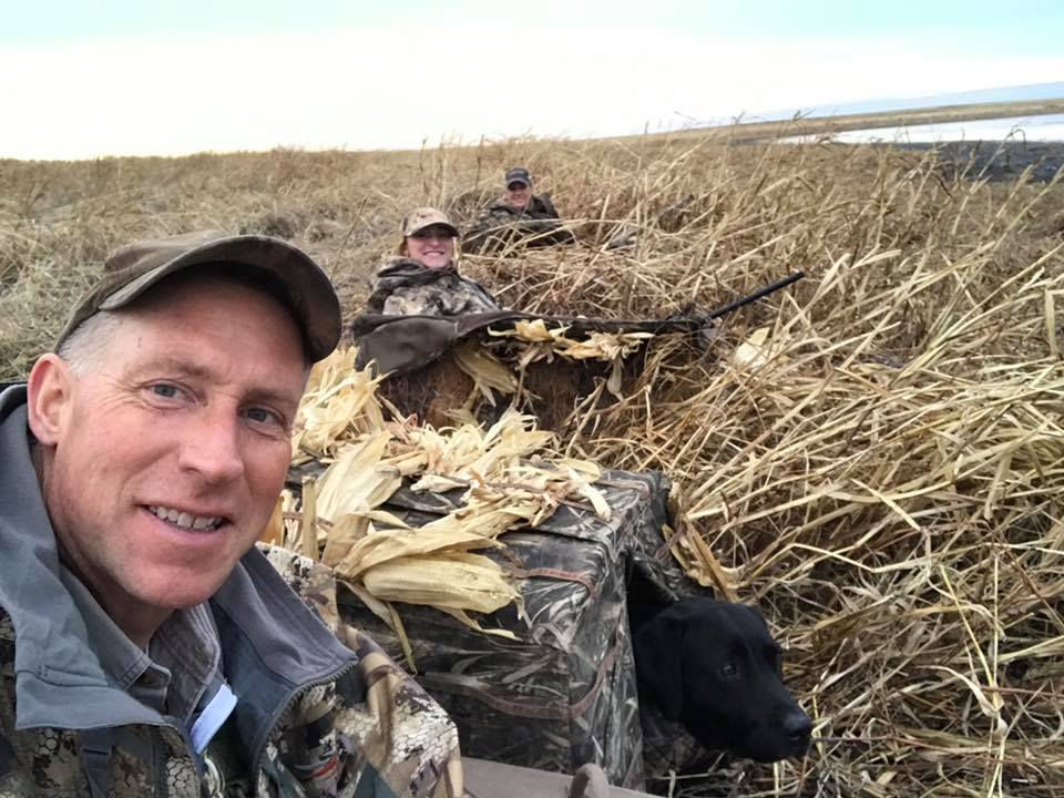 Tallgrass British black male lab in duck blind hunting ducks with father and daughter