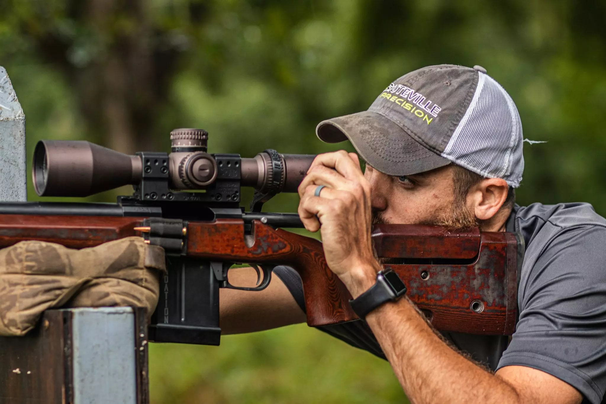 Man adjusting scope on rifle stock