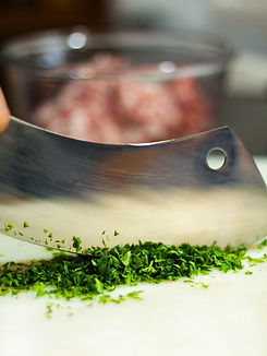 a person chopping green herbs on a cutting board_edited.jpg
