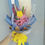 Thumbnail: Single yellow crochet tulip bouquet in blue wrapping with pink fillers.