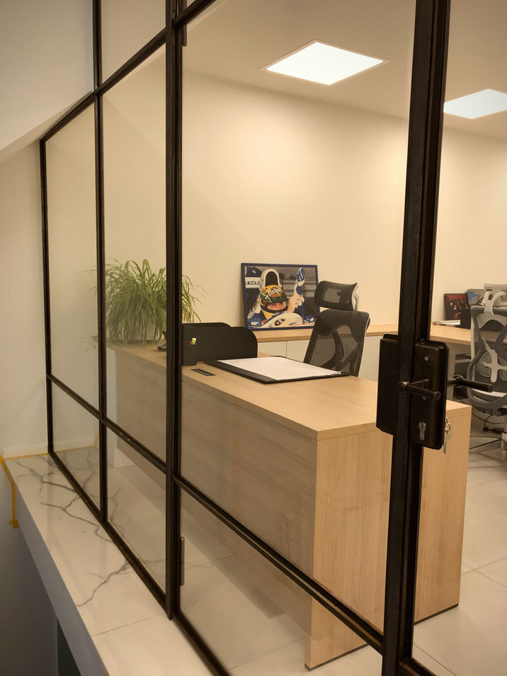 scheidingswand en deur uit gezwart massief staal en bezet met glas