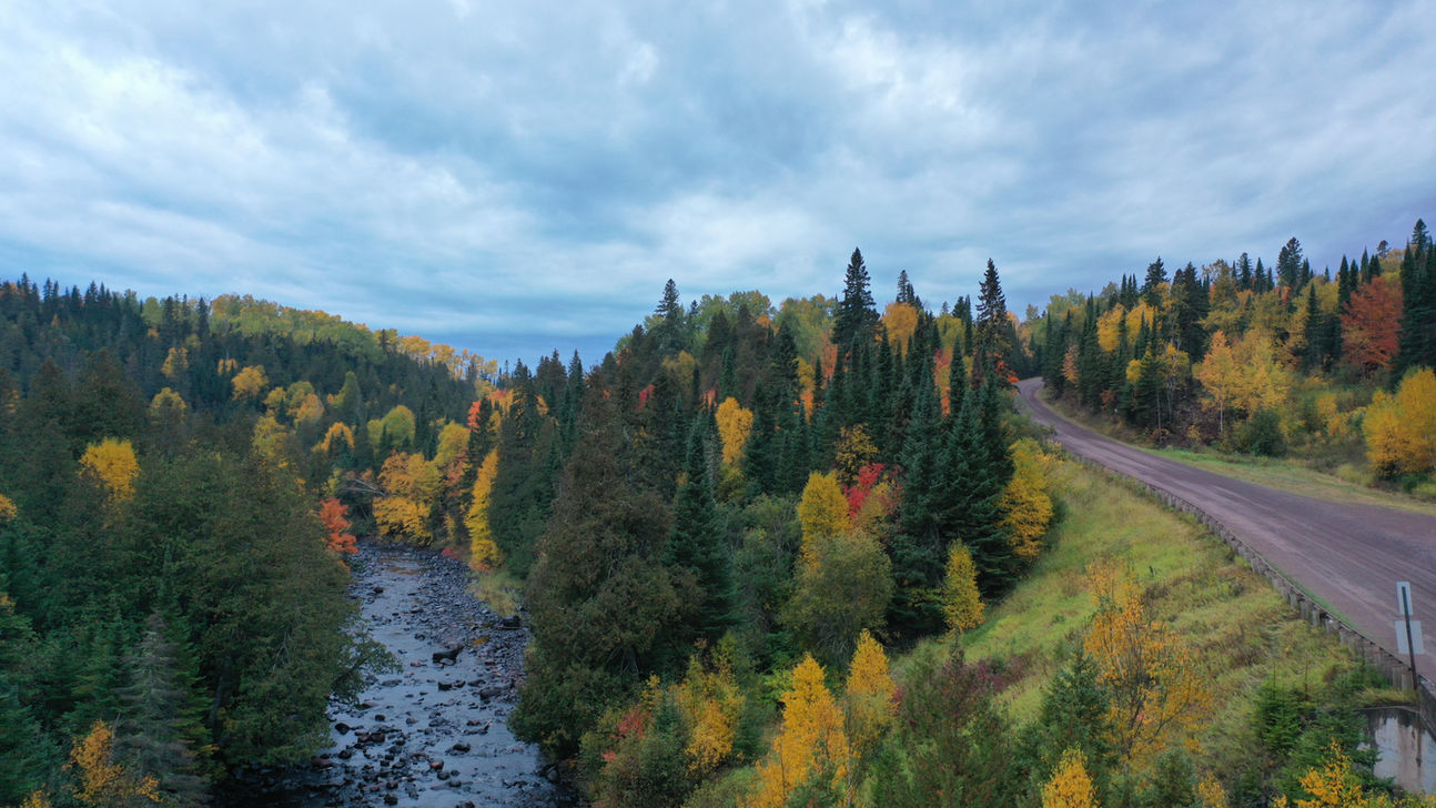 Aerial photo of a river and colorful fall trees.