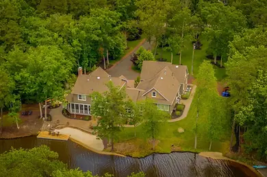 Aerial drone view of a luxury residential property surrounded by lush trees, ideal for real estate listings in Minnesota.