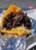 Grilled Venezuelan arepa with shredded beef and cheese