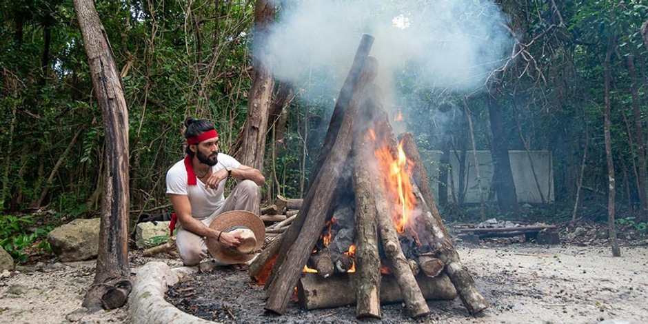 El hombre de fuego viendo arder la madera y calentarse las piedras antes de la ceremonia