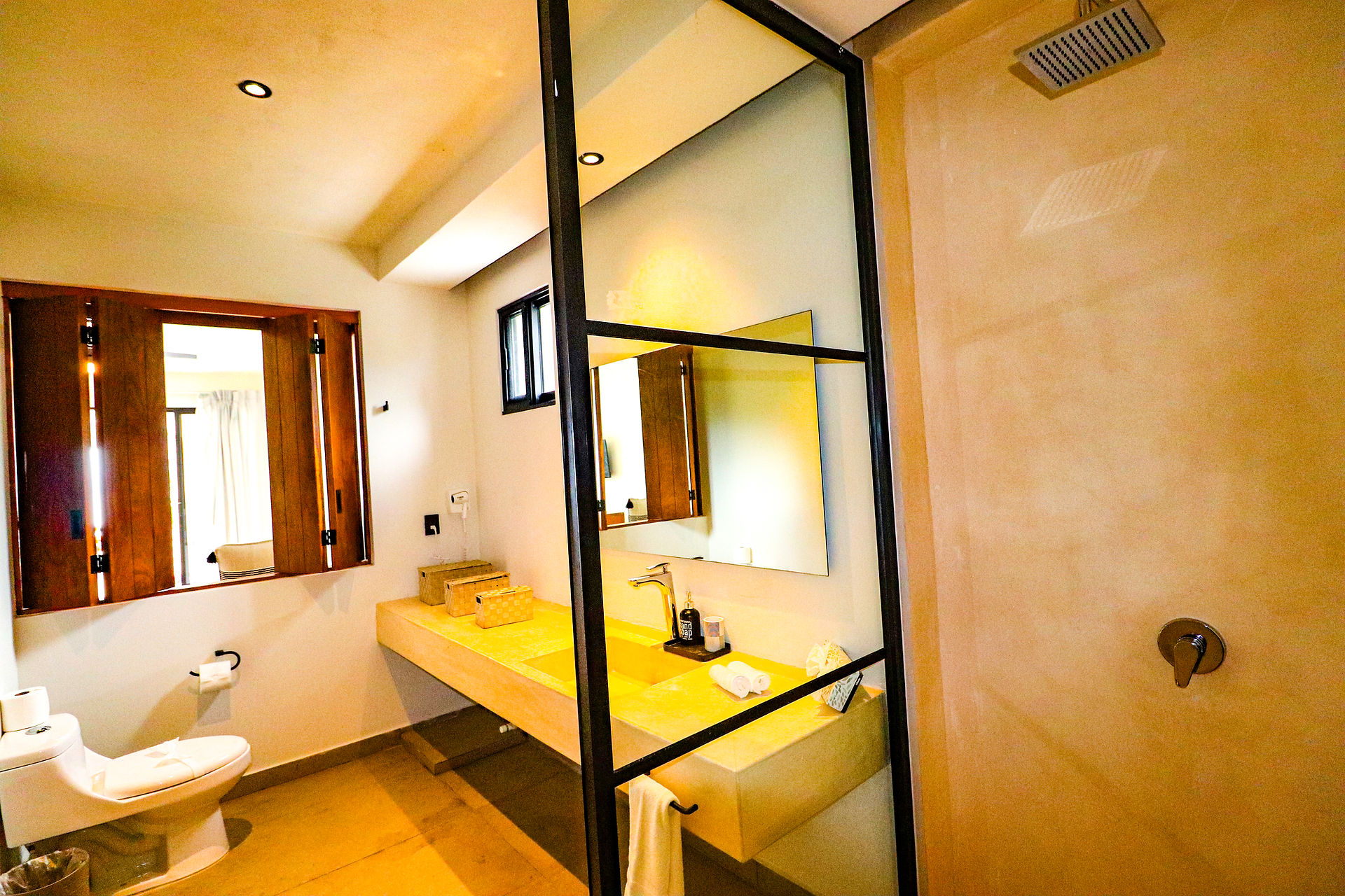 Habitación con baño y acabados en madera en villa de hospedaje para bodas en Akumal