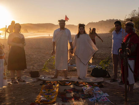 Pareja tomandose de la mano en la playa en una ceremonia