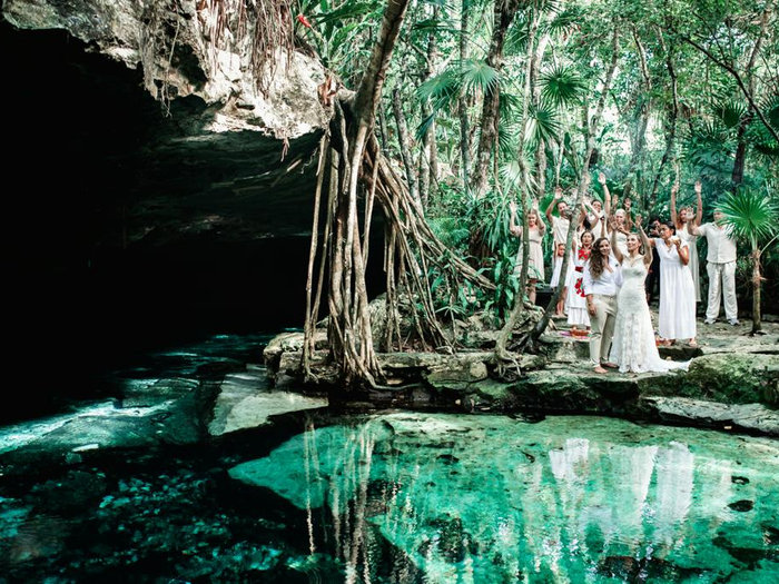 Grupo reunido junto a un cenote turquesa en la selva