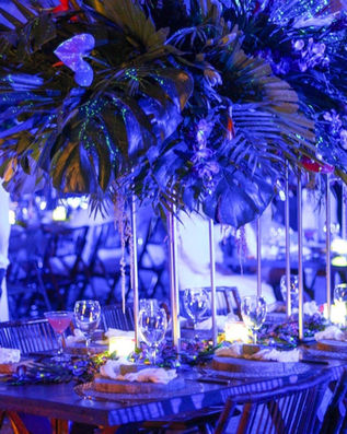 Table set up with high centerpieces painted with the light effect of Avatar