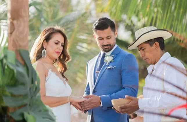 A couple exchanging rings with the celebrant during the ceremony