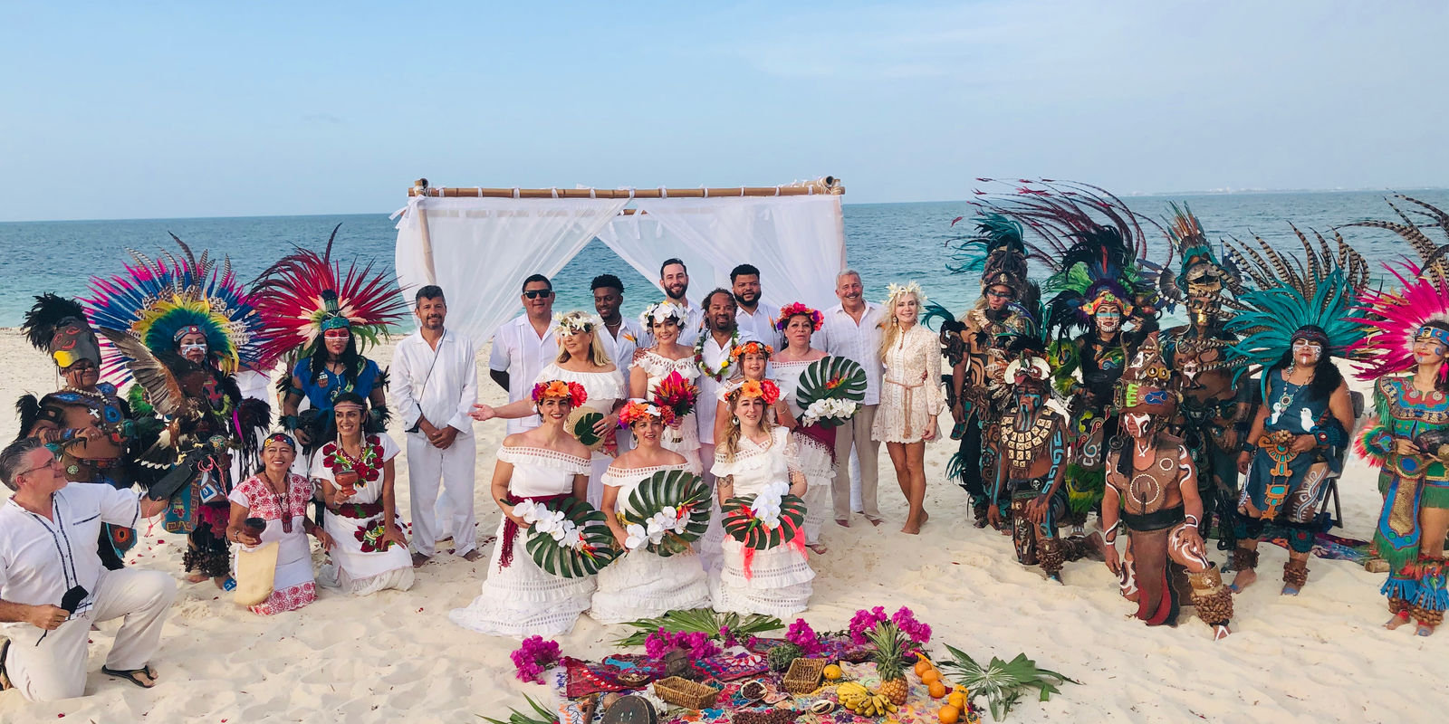 A wedding ceremony on the beach with the whole Mayan prehispanic team, the guests and an offering of flowers on the sand