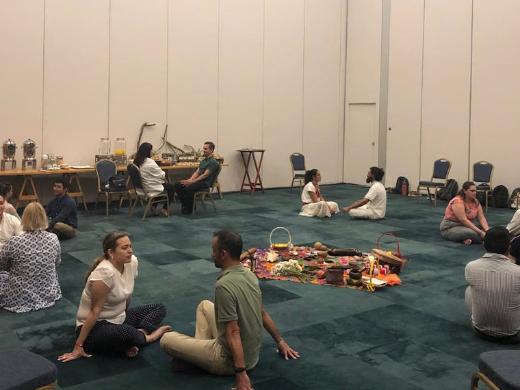 Colleagues sitting on the floor in a circle around the altar